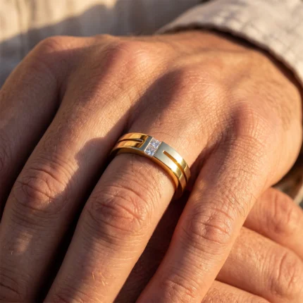 Close-up of a hand wearing a two-tone gold and silver ring with a small diamond accent on the band