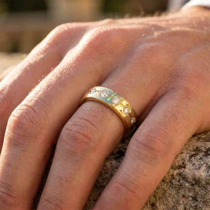 Close-up of a gold band ring with several diamonds worn on a finger resting on a rough rock surface