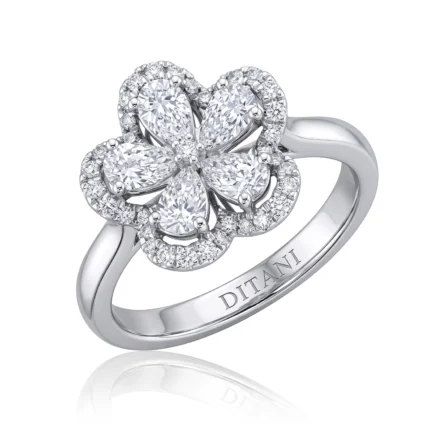 Diamond flower ring set in white gold with pavé halo and a polished band.