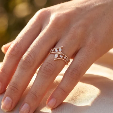 Close-up of a gold ring with twisted bands and diamond accents on a finger in warm sunlight