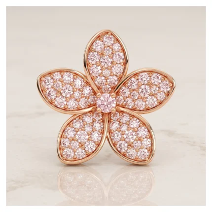 Rose-gold flower-shaped brooch encrusted with pink stones, on a pale background (product image).