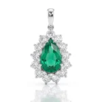 Teardrop emerald pendant surrounded by a halo of diamonds in a silver setting on a pendant