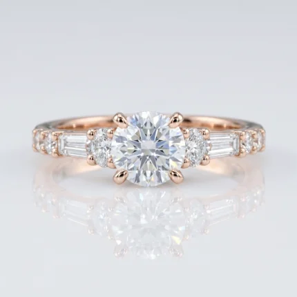 Rose-gold engagement ring with a large round center diamond and baguette-cut side stones on a mirrored surface.
