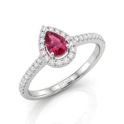 Pear‑cut pink ruby ring with a diamond halo set in white gold, band encrusted with pavé diamonds.