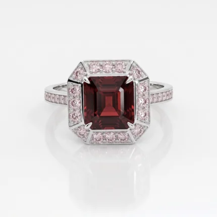 White gold ring featuring a large square-cut deep red center stone, surrounded by pink diamonds in an octagonal setting with a pavé diamond band