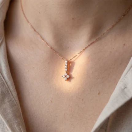 Rose gold necklace with a diamond-studded vertical bar pendant resting on the collarbone area.