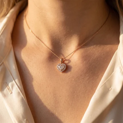 Rose gold heart-shaped diamond pendant on a delicate chain resting against a woman's neck.