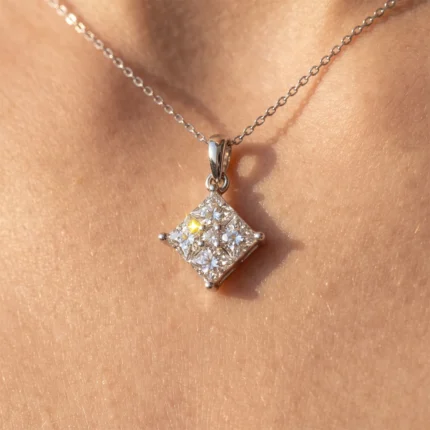 Silver square diamond pendant with multiple small stones on a delicate chain resting on skin