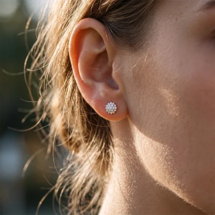 Close-up of a woman's ear with a small star-shaped diamond stud earring.