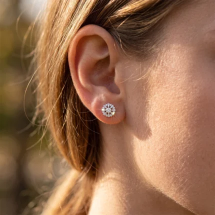 Close-up of a woman's ear wearing a flower-shaped diamond stud earring.