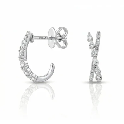 Diamond-studded silver earrings: a pavé hoop and a tall curved drop with diamonds, shown from the side in bright light.