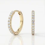 Gold hoop earrings set with round diamonds along the band, two views shown in a jewelry product photo