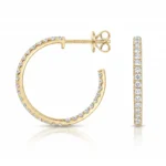 Gold hoop earring with diamonds around the rim and a matching diamond-studded ring beside it, both in polished yellow gold