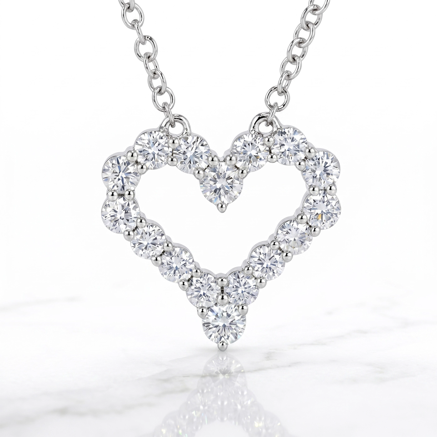 Златно колие с диаманти DITANI бяло злато 2 1 - DITANI Heart-shaped diamond pendant necklace on a silver chain, with round-cut stones forming the outline against a white background.