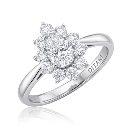 Diamond cluster ring with a central oval stone surrounded by a floral halo of smaller diamonds on a polished band, DITALINI engraved inside.