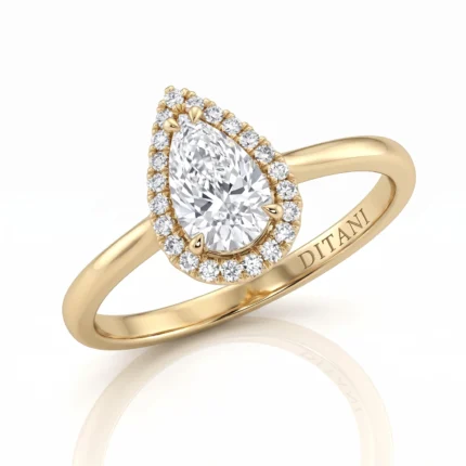 Gold pear-cut diamond ring with halo of small diamonds and diamond-accented bail, engraved 'DITANI' on the inner band