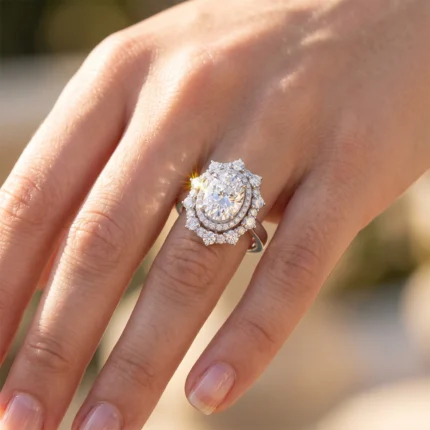 Close-up of a diamond halo ring on a woman's finger, sparkling in sunlight.
