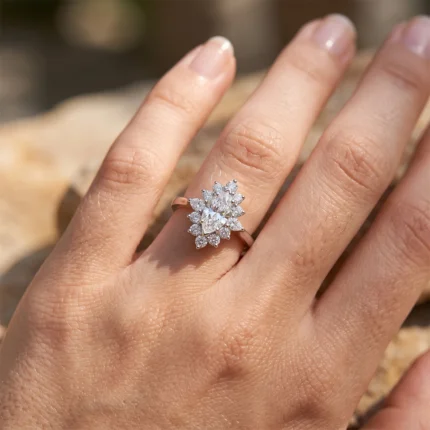 Close-up of a diamond halo ring on the ring finger, sunlit outdoors.