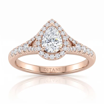 Rose gold engagement ring with a pear-cut center diamond, framed by a double diamond halo and pavé shoulders on the band.