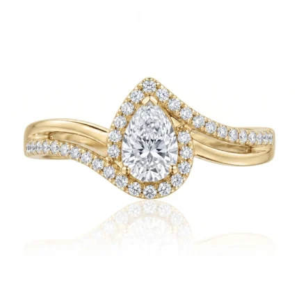 Yellow gold ring with a pear-shaped center diamond surrounded by a halo of smaller diamonds and pavé-set diamonds along the band (split shank).
