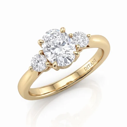 Gold ring with three round diamonds, central large stone flanked by two smaller diamonds in prong settings on a yellow-gold band.