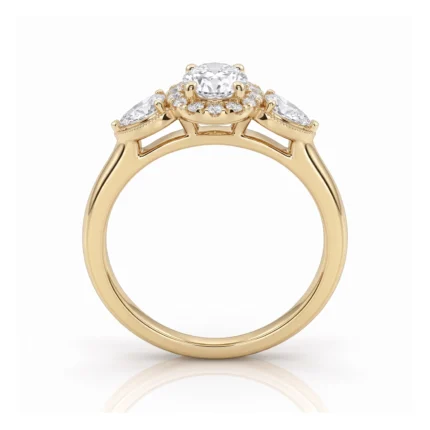 Yellow gold engagement ring with a central round diamond flanked by two marquise-cut stones and a halo of small diamonds.
