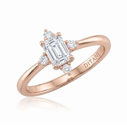 Rose gold ring with a rectangular emerald-cut center diamond and six surrounding small diamonds by the band edge.