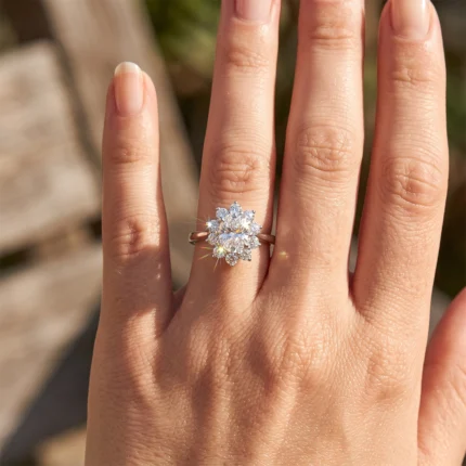 Close-up of a hand wearing a silver ring with a large diamond floral cluster on the ring finger.