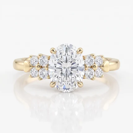 Yellow gold engagement ring with a large oval center diamond, flanked by two clusters of smaller diamonds and heart-shaped band accents.