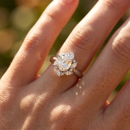 Close-up of a diamond ring with a large central stone surrounded by smaller diamonds on a finger in sunlight for an engagement-style setting
