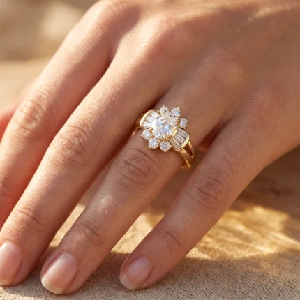 Gold ring with a central pear-cut diamond surrounded by smaller diamonds on the finger of a pale hand in warm light.