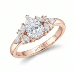 Rose gold ring with a large round brilliant-cut center diamond, flanked by marquise and pear-shaped diamonds on each side, engraved 'DITANI' on the band