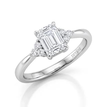 Emerald-cut diamond engagement ring with pave diamonds on the sides in white gold or platinum finish.