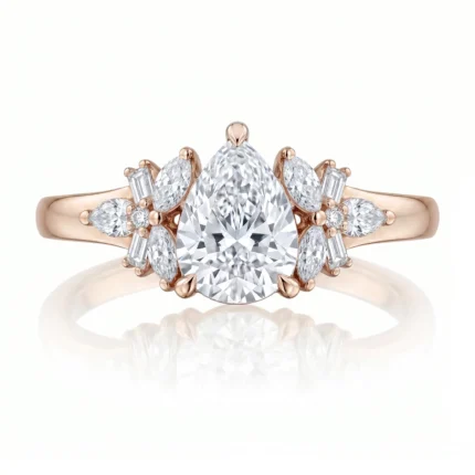 Rose gold ring with a large pear-shaped center diamond and surrounding marquise and baguette diamonds on a thin band.
