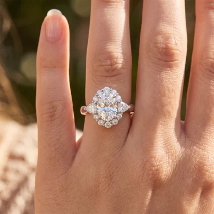 Close-up of a diamond halo ring on the ring finger, featuring a large central stone surrounded by smaller diamonds on a white gold band.