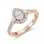 Rose gold engagement ring with a large round center diamond, pear-cut side stones, and a halo of pavé diamonds.