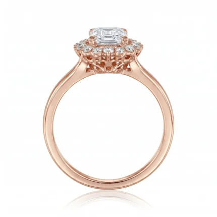 Rose gold engagement ring with an emerald-cut center diamond and a diamond halo above an ornate filigree setting.