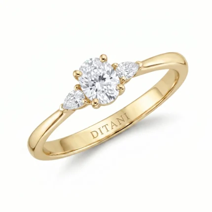 Gold ring featuring a three-diamond setting: a central round diamond with two pear-shaped side stones.